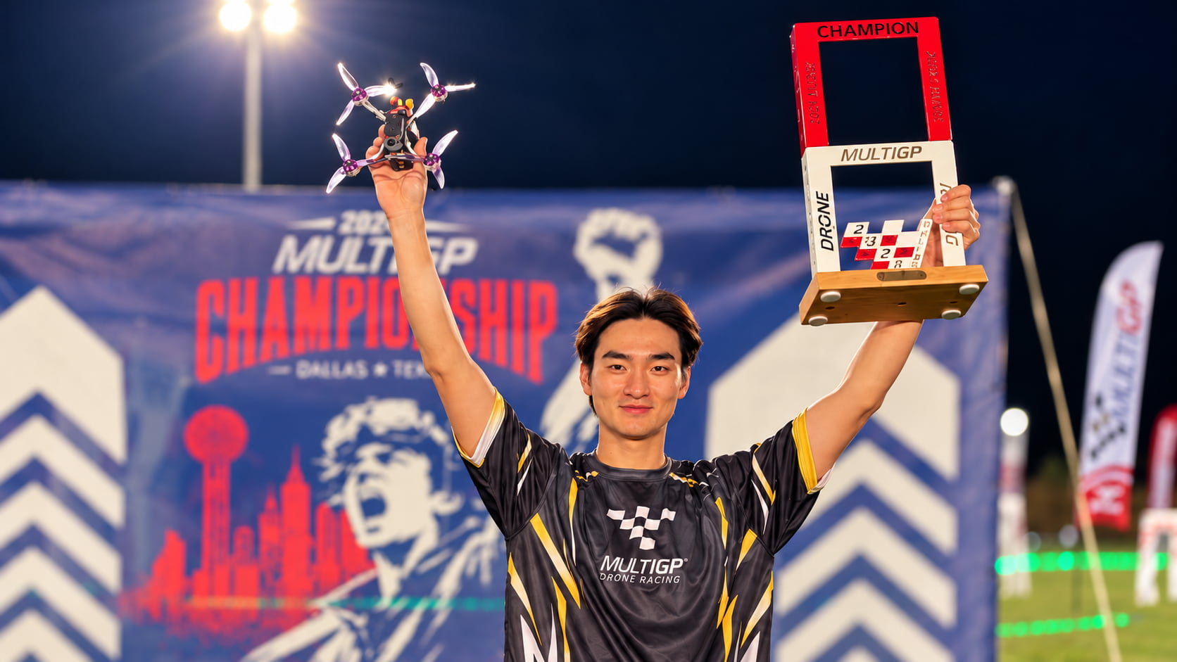 Minchan MCK Kim celebrating his third MultiGP Championship victory with the trophy and drone